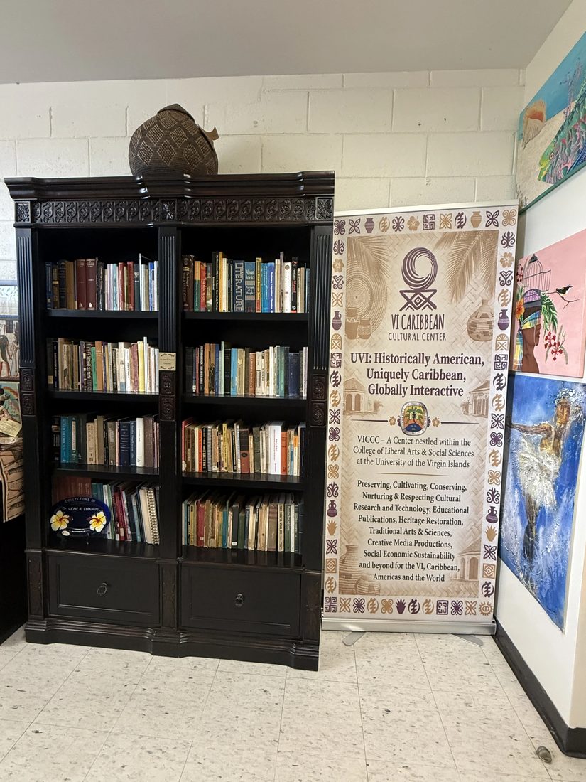 A tall bookcase of Caribbean literature and archival volumes inside the VICCC reading room.