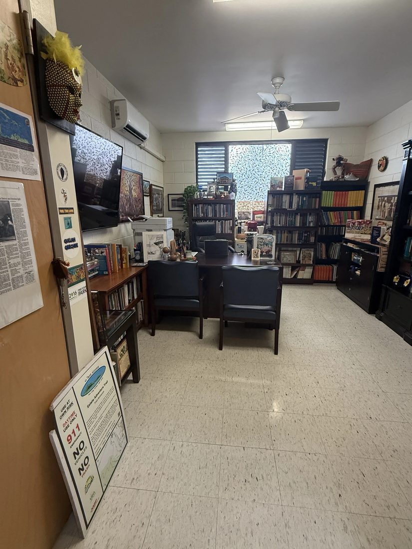 The VICCC office and reading area, with bookshelves, a desk, and community bulletin board.