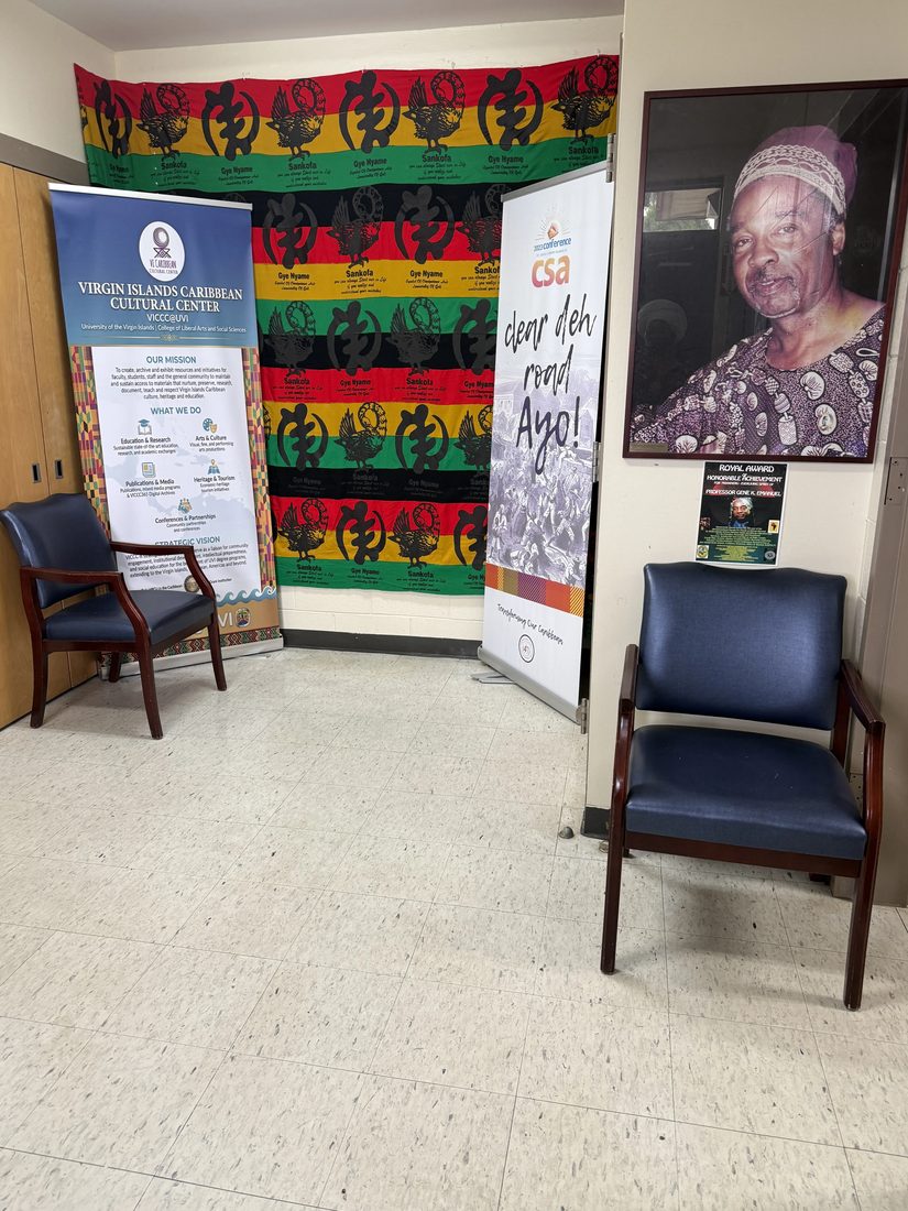 A seating area with VICCC banners, an Adinkra-print backdrop, and a portrait on the wall.