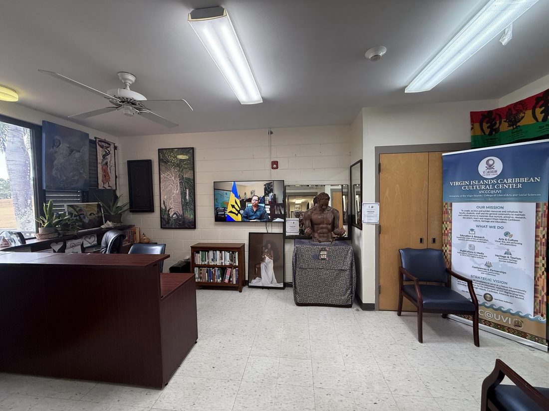 The VICCC front office with a desk, bookshelf, seating, and a wall of framed artwork.